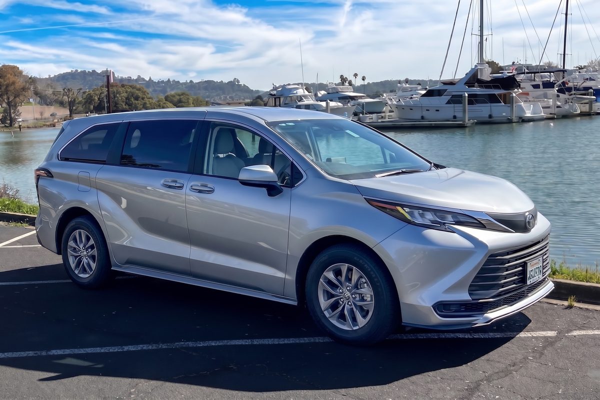 Silver Toyota Sienna parked beside a marina