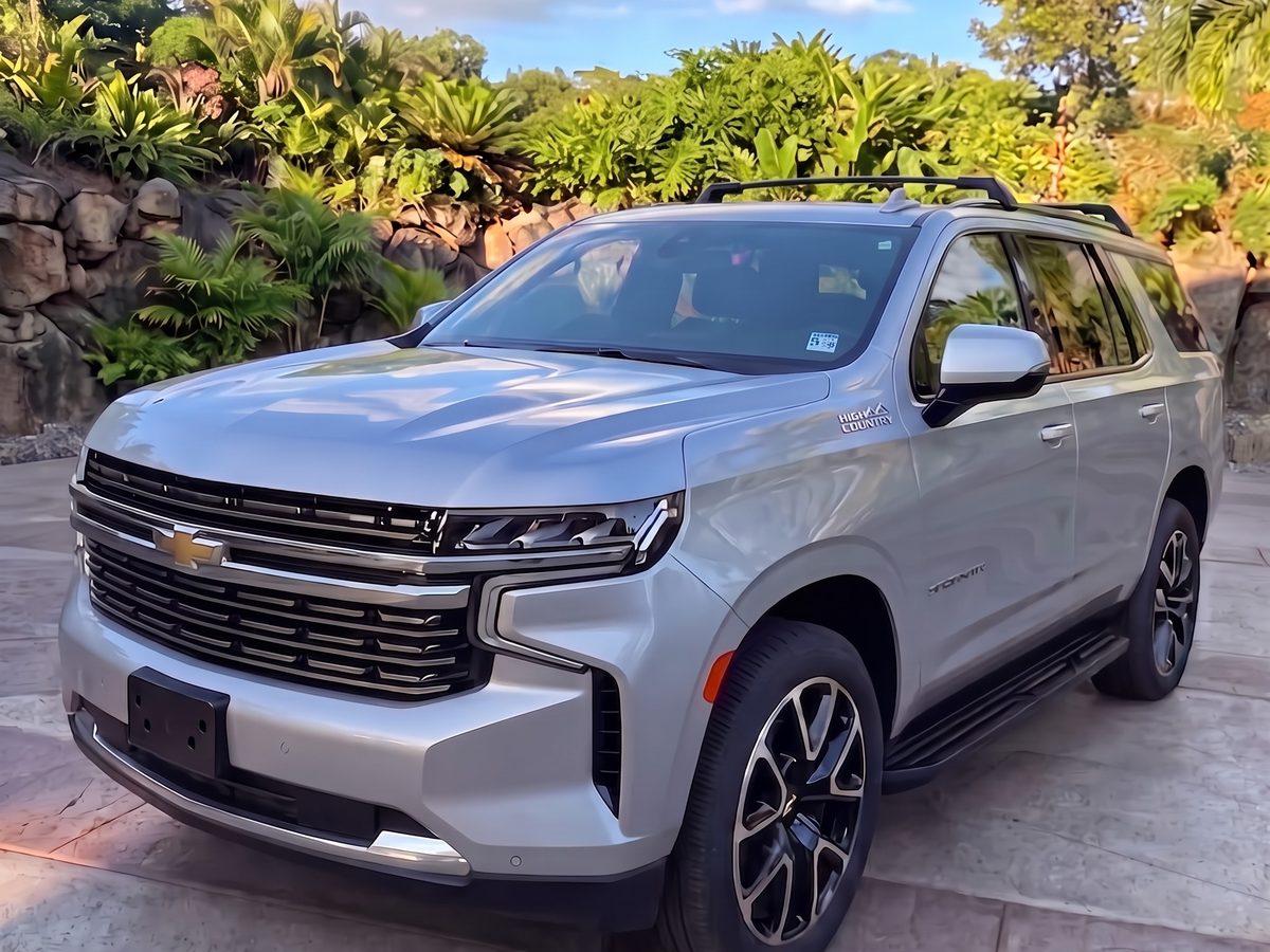 Silver Chevrolet Tahoe High Country in a Maui driveway under palms
